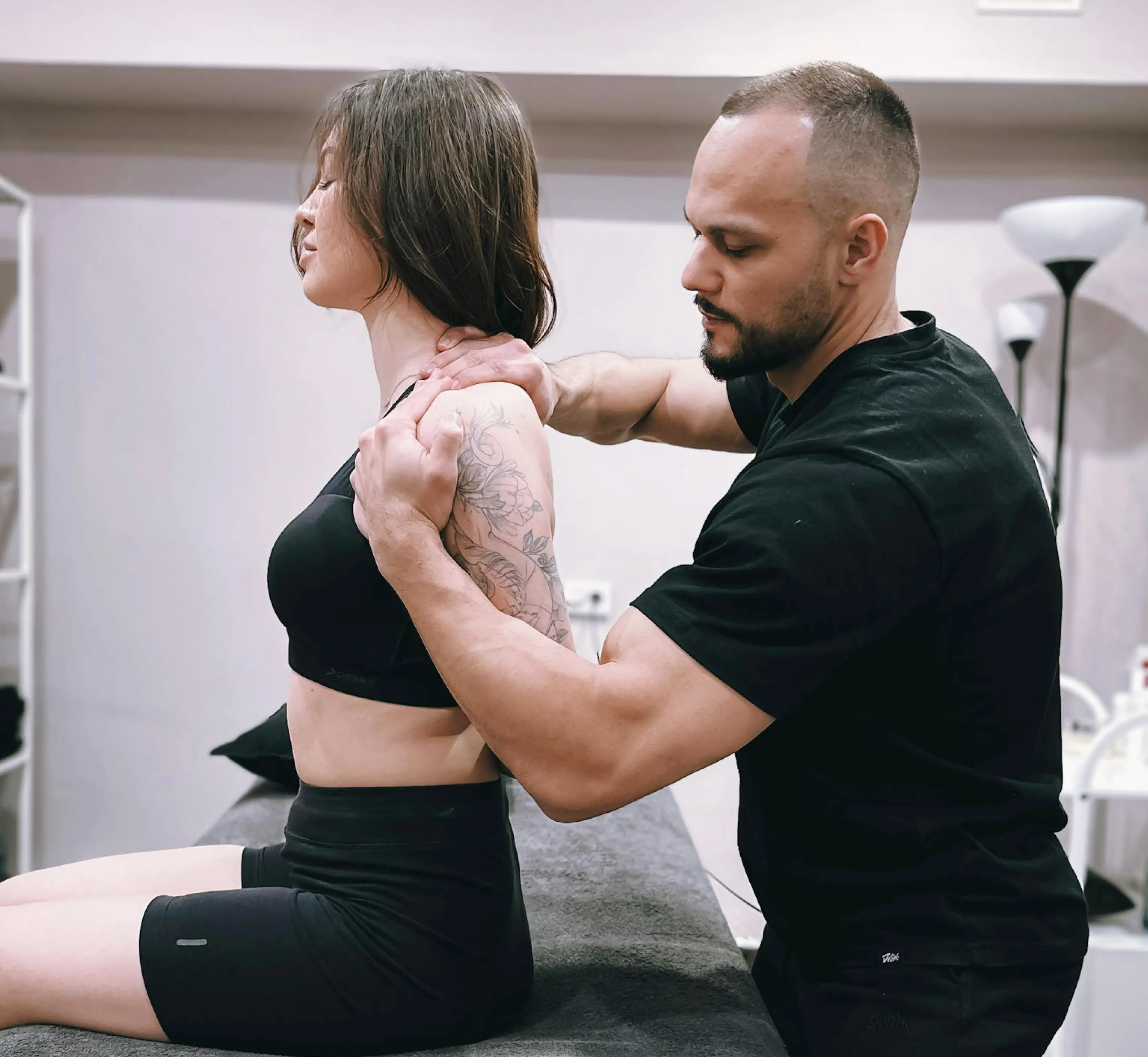 Chiropractor doing a maneuver on the shoulder of a woman